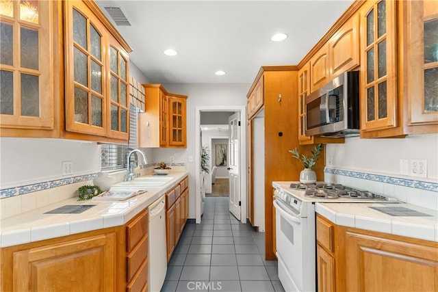 1518 Ocean Ave, Seal Beach, CA 90740 - kitchen with white appliances, a sink, tile patterned floors, glass insert cabinets, and tile countertops