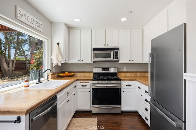 2818 Via Blanco, San Clemente, CA 92673 - kitchen with stainless steel appliances, a sink, white cabinets, dark wood finished floors, and light countertops