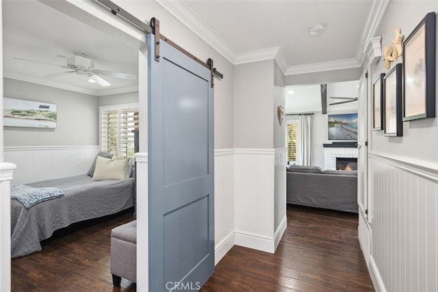 2818 Via Blanco, San Clemente, CA 92673 - bedroom featuring a barn door, wainscoting, multiple windows, ornamental molding, and hardwood / wood-style floors
