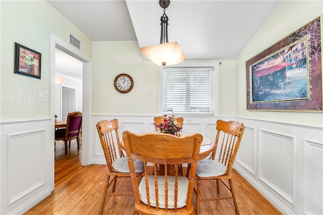11628 Cedarvale St, Norwalk, CA 90650 - dining area with light wood-style floors, a wainscoted wall, a decorative wall, and vaulted ceiling