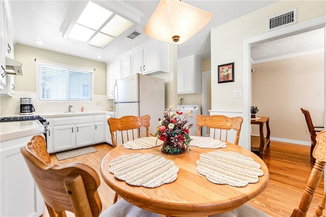 11628 Cedarvale St, Norwalk, CA 90650 - dining space with washer / clothes dryer, light wood-type flooring, recessed lighting, and ornamental molding