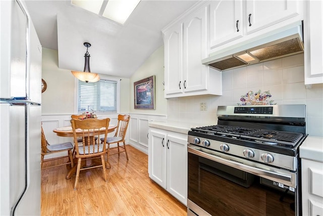 11628 Cedarvale St, Norwalk, CA 90650 - kitchen with gas stove, white cabinets, light countertops, a wainscoted wall, and vaulted ceiling