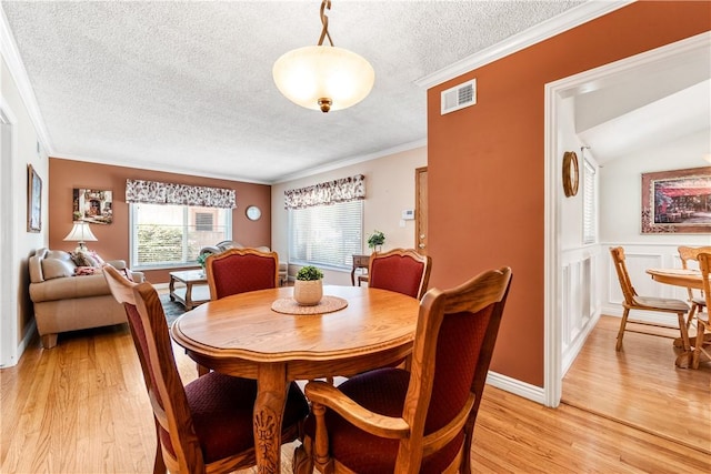 11628 Cedarvale St, Norwalk, CA 90650 - dining space with a textured ceiling, light wood-type flooring, and crown molding