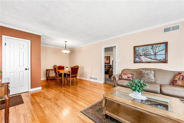 11628 Cedarvale St, Norwalk, CA 90650 - living room with light wood finished floors, crown molding, a textured ceiling, and baseboards