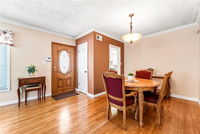 11628 Cedarvale St, Norwalk, CA 90650 - dining space featuring a textured ceiling, light wood-style floors, healthy amount of natural light, crown molding, and baseboards