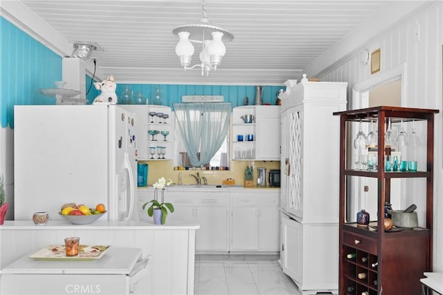 211 S K St, Lompoc, CA 93436 - kitchen featuring white fridge with ice dispenser, light marble finish flooring, a chandelier, white cabinetry, and light countertops