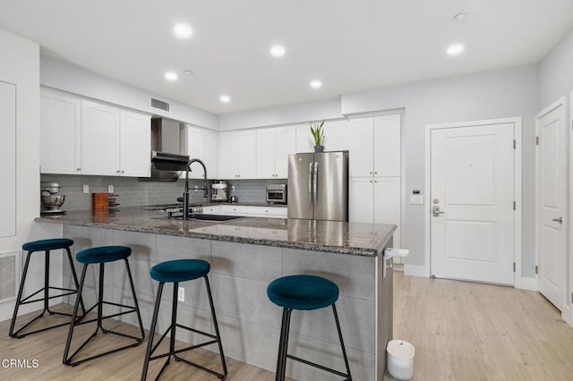 13124 Central Ave Unit 201, Hawthorne, CA 90250 - kitchen featuring freestanding refrigerator, a peninsula, a sink, light wood-style flooring, and white cabinetry