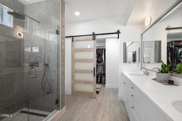 13124 Central Ave Unit 201, Hawthorne, CA 90250 - full bathroom with a walk in closet, double vanity, a shower stall, wood finished floors, and baseboards