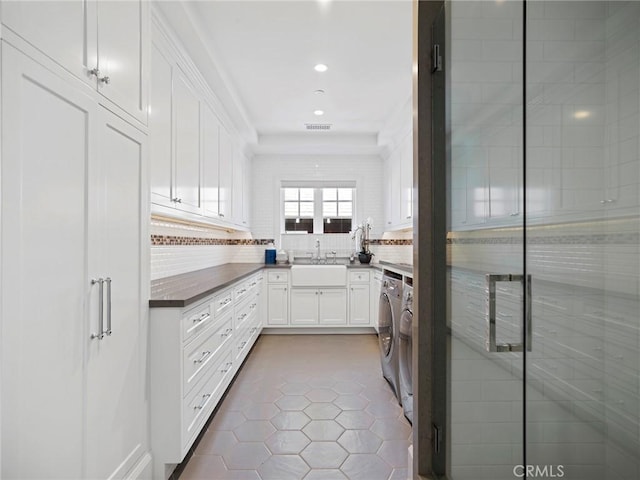 1324 E Balboa Blvd, Newport Beach, CA 92661 - kitchen with a sink, separate washer and dryer, tile patterned floors, white cabinetry, and decorative backsplash