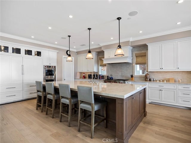1324 E Balboa Blvd, Newport Beach, CA 92661 - kitchen with stainless steel double oven, a large island, white cabinetry, tasteful backsplash, and crown molding
