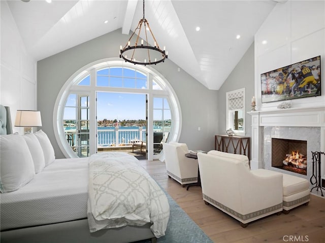 1324 E Balboa Blvd, Newport Beach, CA 92661 - bedroom with light wood-type flooring, access to exterior, multiple windows, a chandelier, and high vaulted ceiling
