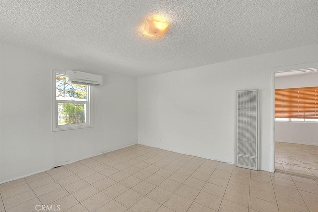 1507 4th St, Norco, CA 92860 - empty room featuring a heating unit, healthy amount of natural light, a wall mounted air conditioner, a textured ceiling, and light tile patterned floors