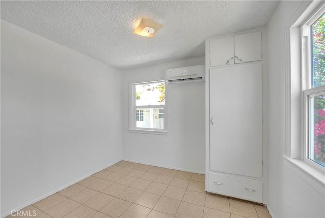 1507 4th St, Norco, CA 92860 - unfurnished bedroom featuring a wall mounted air conditioner, a textured ceiling, multiple windows, light tile patterned flooring, and baseboards