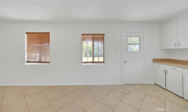 1507 4th St, Norco, CA 92860 - kitchen with light countertops, white cabinetry, light tile patterned floors, and baseboards
