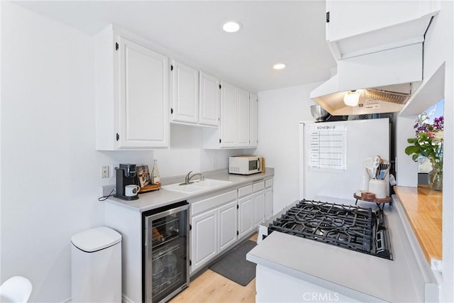 660 S Glassell St Unit 14, Orange, CA 92866 - kitchen with white appliances, a sink, beverage cooler, light countertops, and white cabinetry