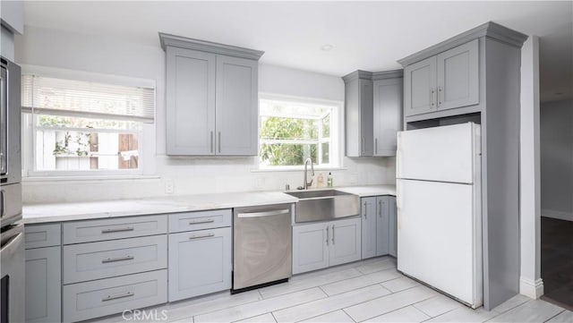 1541 N Stanley Ave, Los Angeles, CA 90046 - kitchen featuring freestanding refrigerator, stainless steel dishwasher, gray cabinetry, a sink, and light stone countertops