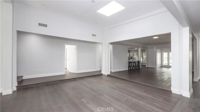 1541 N Stanley Ave, Los Angeles, CA 90046 - unfurnished living room featuring wood finished floors, baseboards, and a towering ceiling