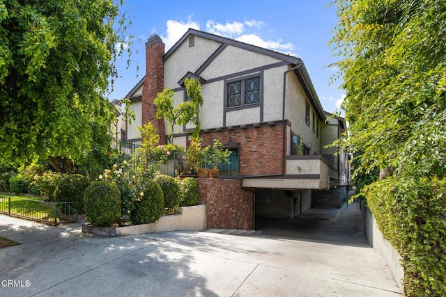 11940 Weddington St Unit 19, Valley Village, CA 91607 - view of front of home featuring stucco siding, a chimney, brick siding, and driveway