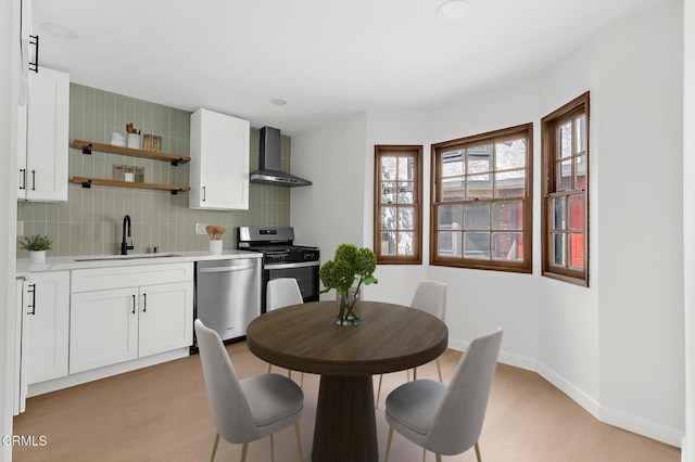 11940 Weddington St Unit 19, Valley Village, CA 91607 - kitchen featuring appliances with stainless steel finishes, wall chimney exhaust hood, light countertops, and light wood finished floors