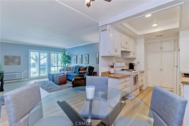 2109 Via Puerta Unit A, Laguna Woods, CA 92637 - kitchen featuring white appliances, light wood-style floors, white cabinets, open floor plan, and under cabinet range hood