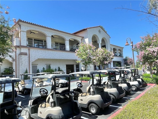2109 Via Puerta Unit A, Laguna Woods, CA 92637 - view of front of home featuring stucco siding, a tiled roof, a balcony, and parking