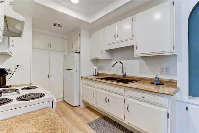 2109 Via Puerta Unit A, Laguna Woods, CA 92637 - kitchen with white appliances, a sink, light wood-style flooring, light countertops, and a tray ceiling