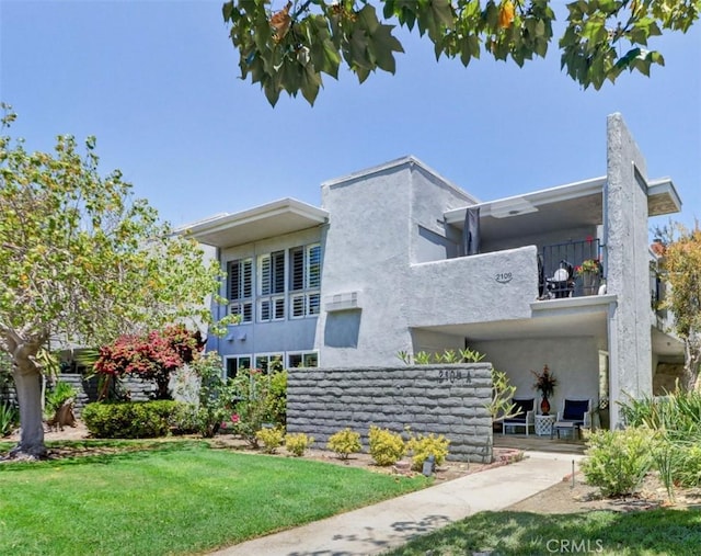 2109 Via Puerta Unit A, Laguna Woods, CA 92637 - rear view of property featuring a balcony, a lawn, and stucco siding