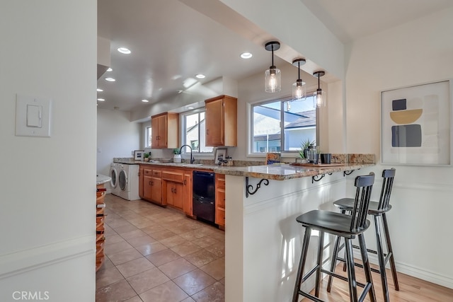3562 N Studebaker, Long Beach, CA 90808 - kitchen with black dishwasher, washer and clothes dryer, a sink, a breakfast bar area, and recessed lighting