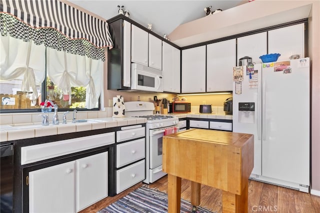 73 Mockingbird Ln, Templeton, CA 93465 - kitchen featuring white appliances, tile counters, a sink, white cabinets, and lofted ceiling