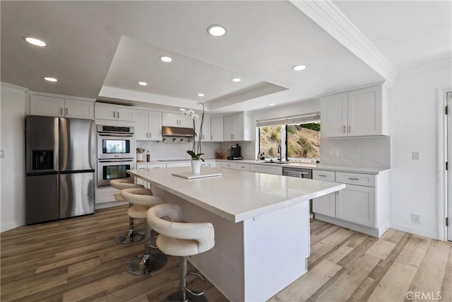 12235 Circula Panorama, North Tustin, CA 92705 - kitchen with appliances with stainless steel finishes, recessed lighting, a tray ceiling, light wood finished floors, and white cabinetry