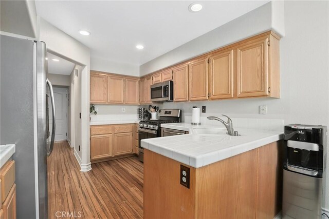 18102 Flynn Dr Unit 4602, Canyon Country, CA 91387 - kitchen with stainless steel appliances, a sink, wood finished floors, a peninsula, and recessed lighting