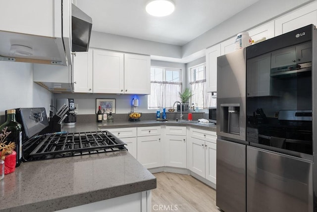 158 W Del Amo Blvd, Long Beach, CA 90805 - kitchen with exhaust hood, white cabinetry, range with gas cooktop, light wood-type flooring, and dark stone counters