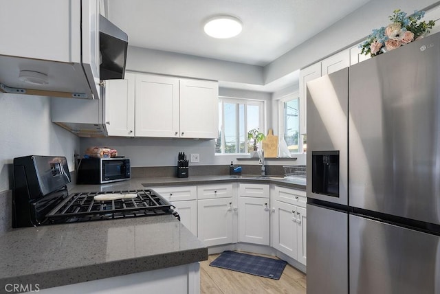 158 W Del Amo Blvd, Long Beach, CA 90805 - kitchen with stainless steel fridge with ice dispenser, black microwave, white cabinets, and range with gas cooktop