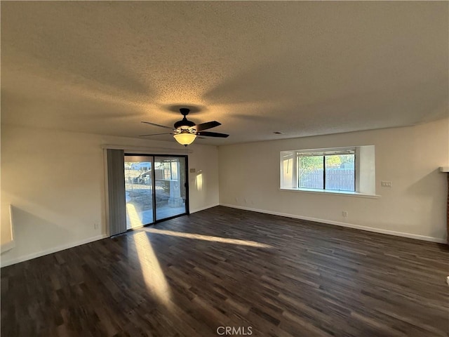 15332 Tuscola Rd, Apple Valley, CA 92307 - unfurnished room featuring plenty of natural light, a textured ceiling, dark wood finished floors, and baseboards