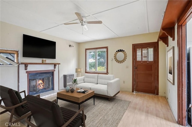 1385 Turquoise Ave, Mentone, CA 92359 - living room featuring a glass covered fireplace, a ceiling fan, and light wood finished floors