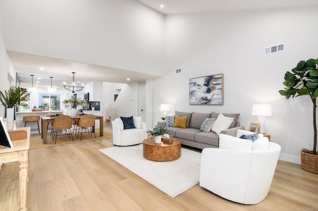 4161 Rhodes Way, Oceanside, CA 92056 - living area featuring light wood-style flooring, recessed lighting, a chandelier, a high ceiling, and baseboards