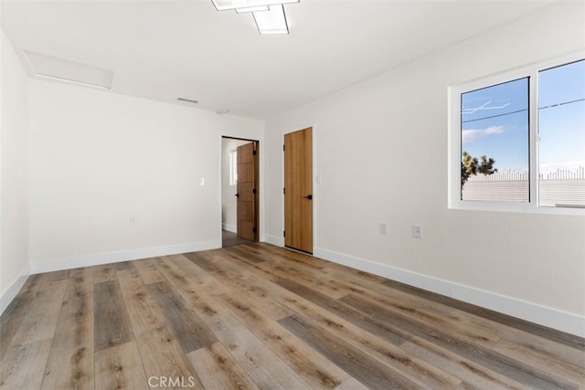 60468 Latham Trl, Joshua Tree, CA 92252 - unfurnished room featuring wood finished floors, baseboards, and attic access