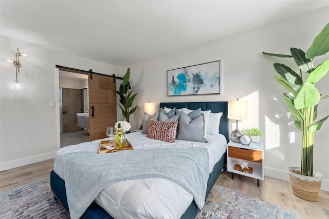 60468 Latham Trl, Joshua Tree, CA 92252 - bedroom featuring a barn door, wood finished floors, and baseboards
