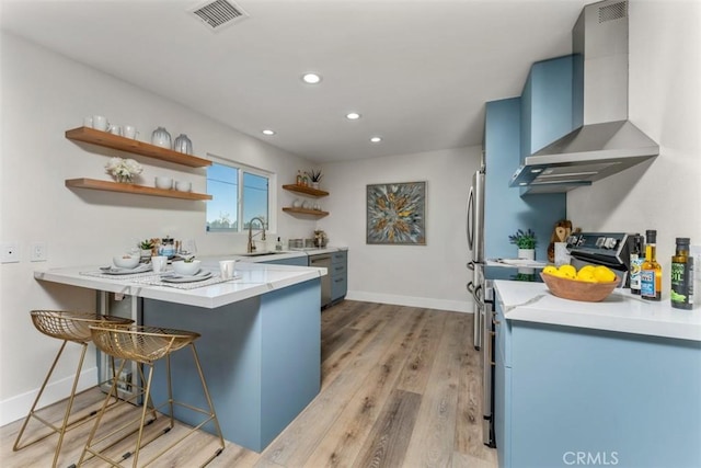 60468 Latham Trl, Joshua Tree, CA 92252 - kitchen featuring wall chimney range hood, blue cabinetry, open shelves, a sink, and recessed lighting