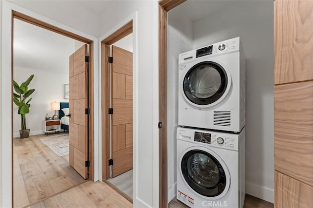 60468 Latham Trl, Joshua Tree, CA 92252 - laundry area featuring stacked washer / dryer, wood finished floors, and baseboards