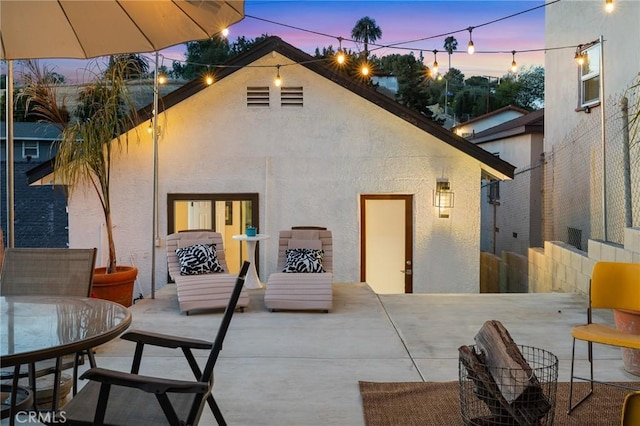 4142 Mercury Ave, Los Angeles, CA 90031 - back of property at dusk with stucco siding, a patio, and outdoor dining area