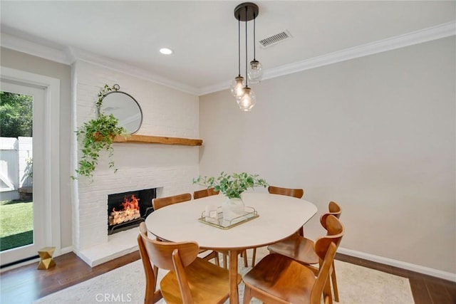2486 Napoli Way, Costa Mesa, CA 92627 - dining room featuring a brick fireplace, wood finished floors, crown molding, baseboards, and recessed lighting
