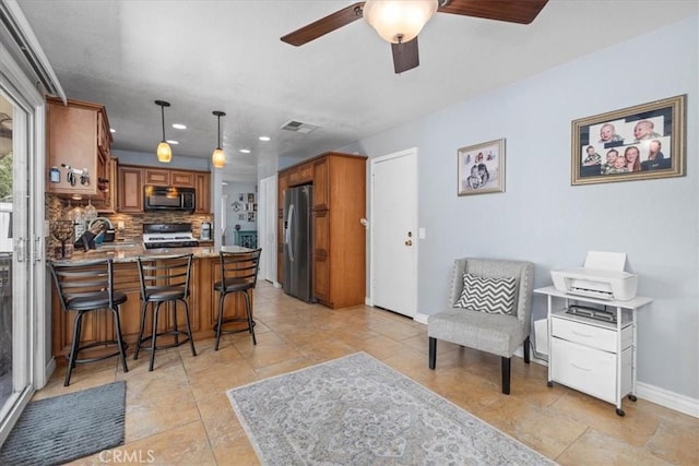 6600 Montresor Pl, Rancho Cucamonga, CA 91737 - kitchen with black microwave, gas range, stainless steel fridge, brown cabinetry, and a peninsula