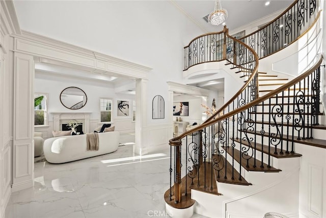 4840 Temple City Blvd, Temple City, CA 91780 - stairway with a decorative wall, marble tiled flooring, crown molding, a wainscoted wall, and a chandelier