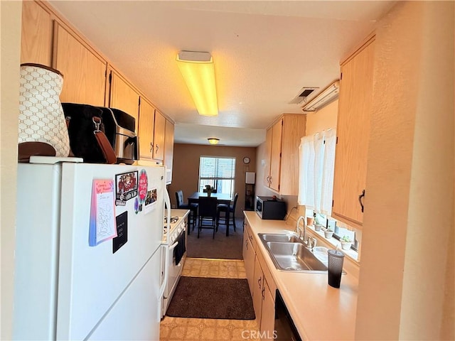 631 N St, Corning, CA 96021 - kitchen featuring white appliances, a sink, light brown cabinets, and light countertops