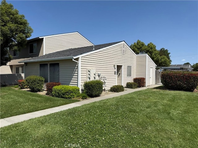 631 N St, Corning, CA 96021 - view of property exterior featuring a lawn and roof with shingles