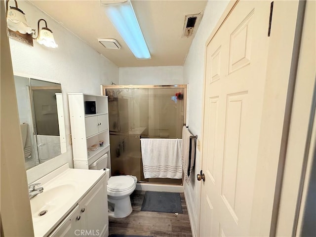 631 N St, Corning, CA 96021 - full bathroom featuring a stall shower, wood finished floors, vanity, and toilet