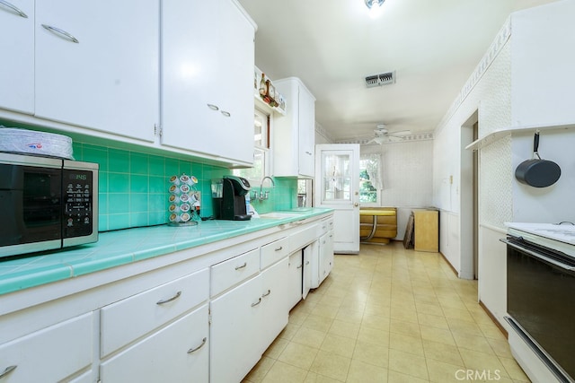 2407 E Walnut Crk, West Covina, CA 91791 - kitchen featuring stainless steel microwave, electric stove, a sink, white cabinets, and a ceiling fan
