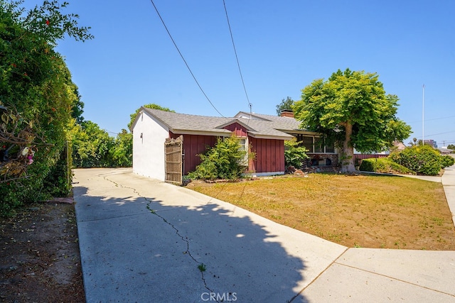 2407 E Walnut Crk, West Covina, CA 91791 - view of side of home featuring a lawn, board and batten siding, and driveway
