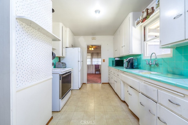 2407 E Walnut Crk, West Covina, CA 91791 - kitchen with white appliances, white cabinets, a ceiling fan, backsplash, and tile counters